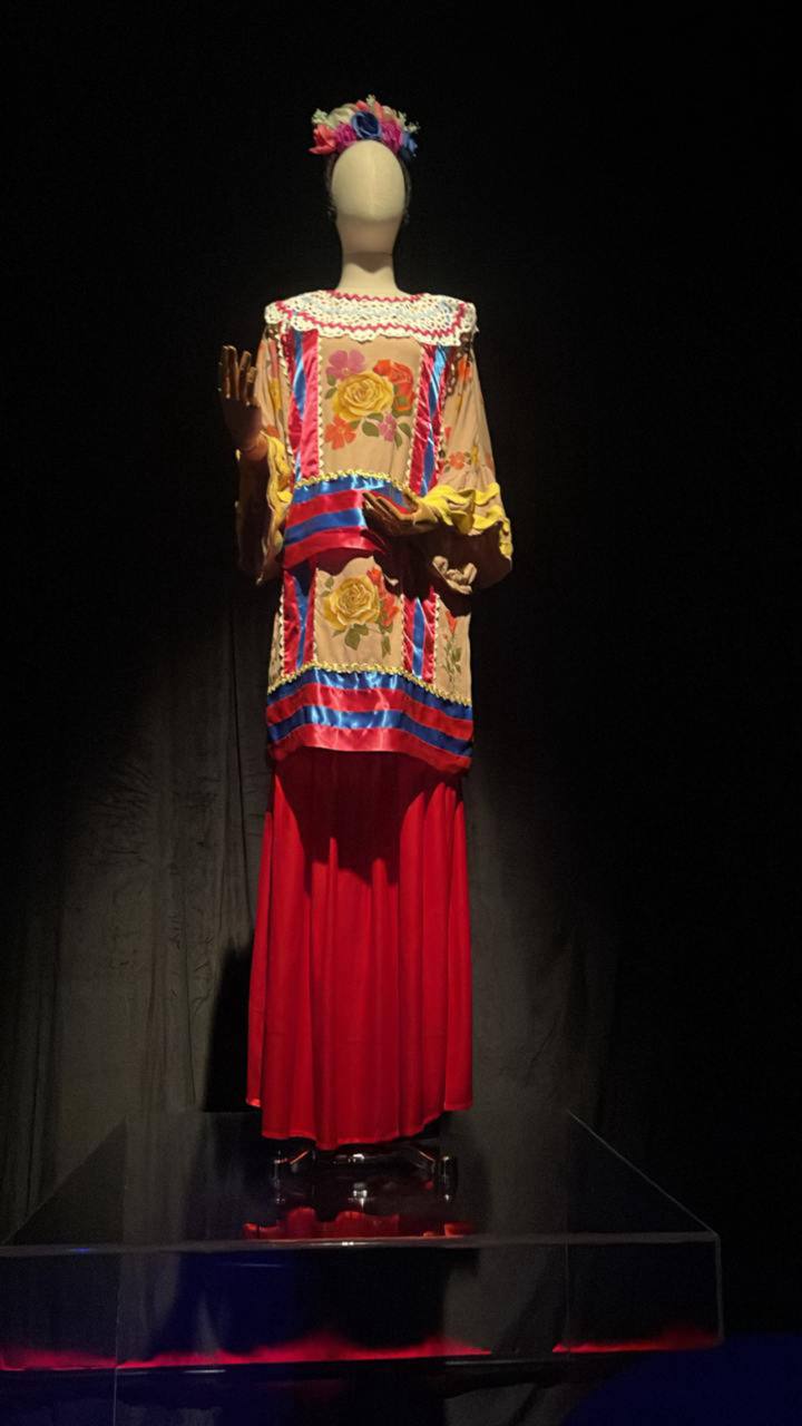 Manequim com vestido tradicional colorido e cocar flores em museu